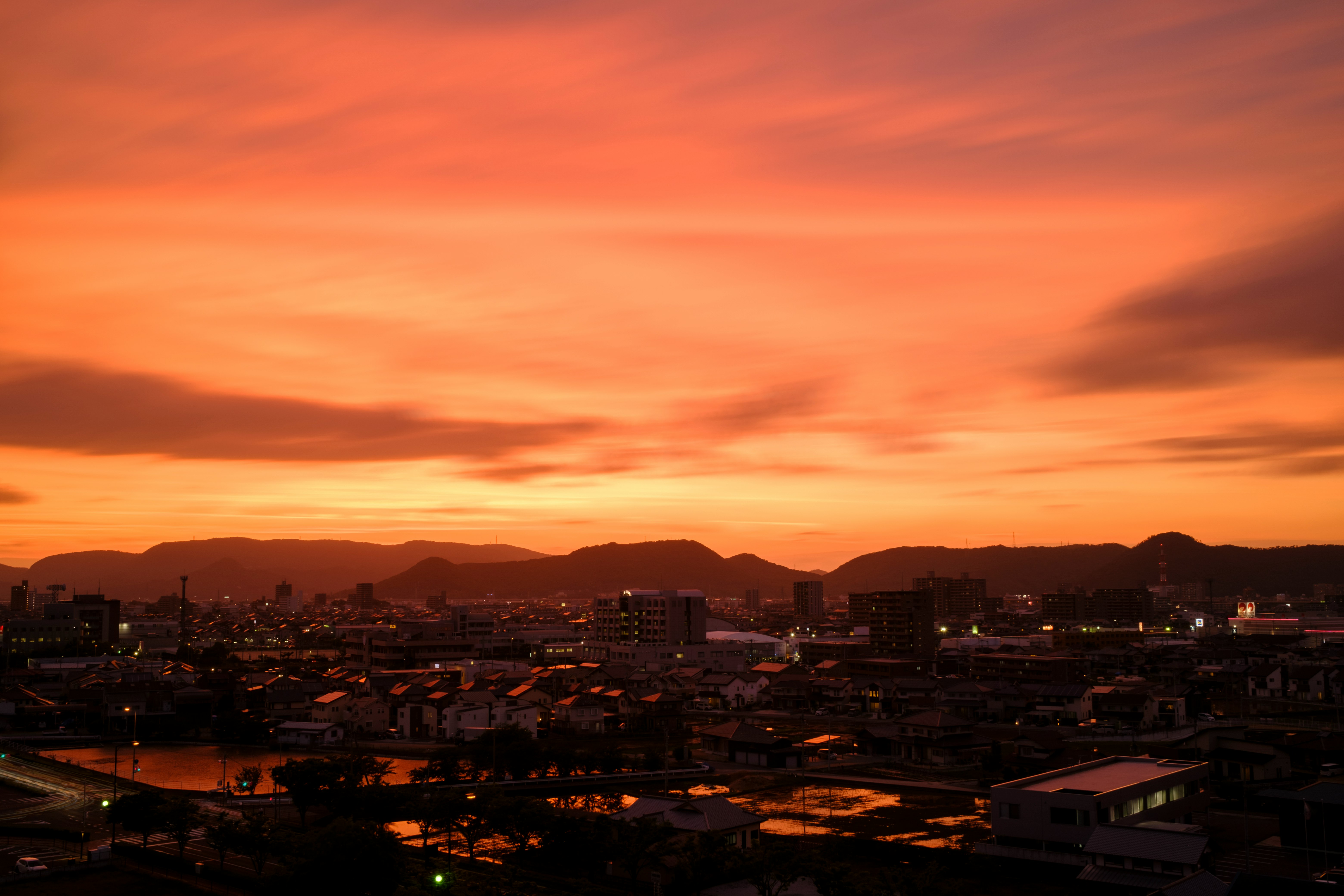 city with high rise buildings under orange and gray sky